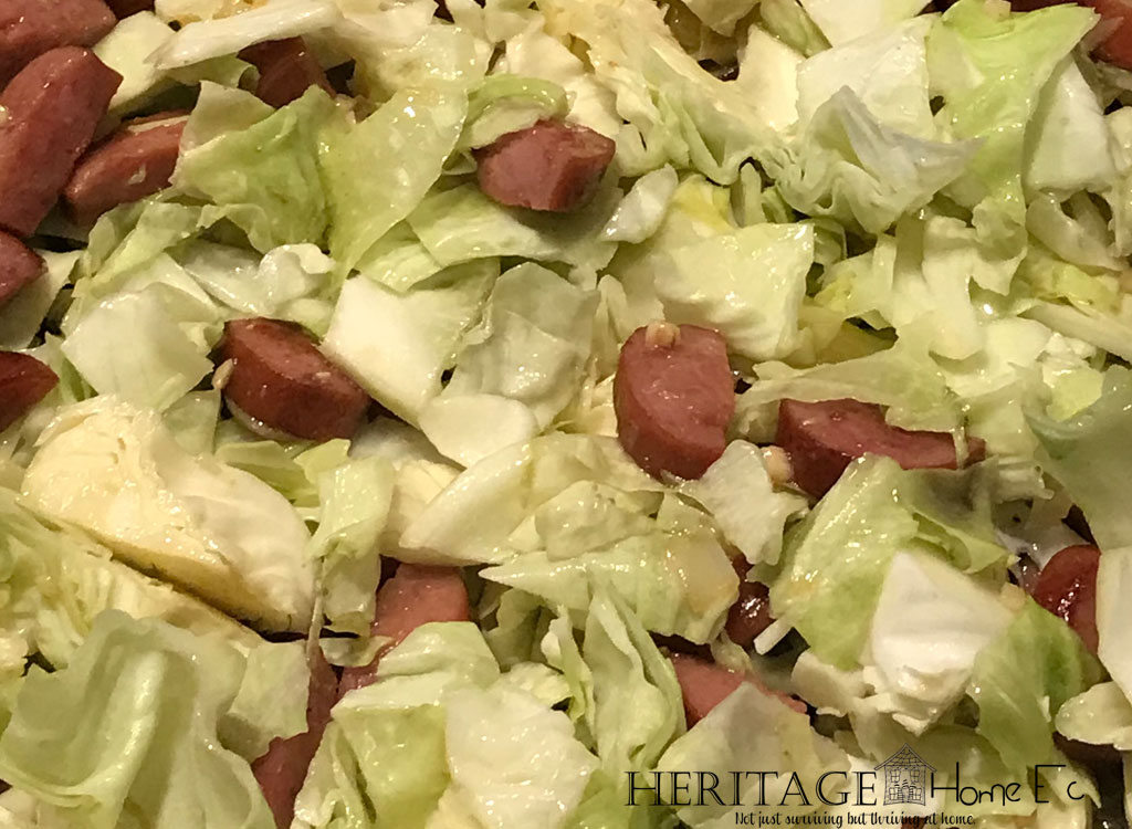 cabbage cooking in skillet with kielbasa