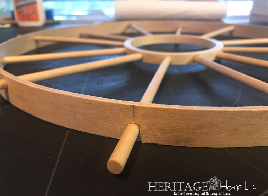 closeup of wooden dowels through drilled holes in embroidery hoop