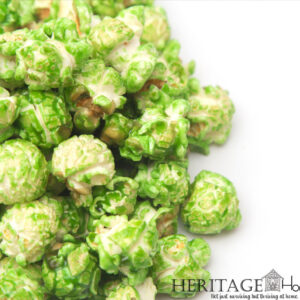 green candy-coated popcorn on white background
