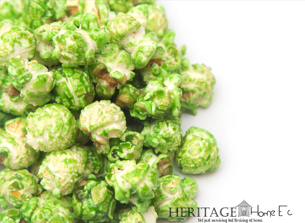 green candy-coated popcorn on white background
