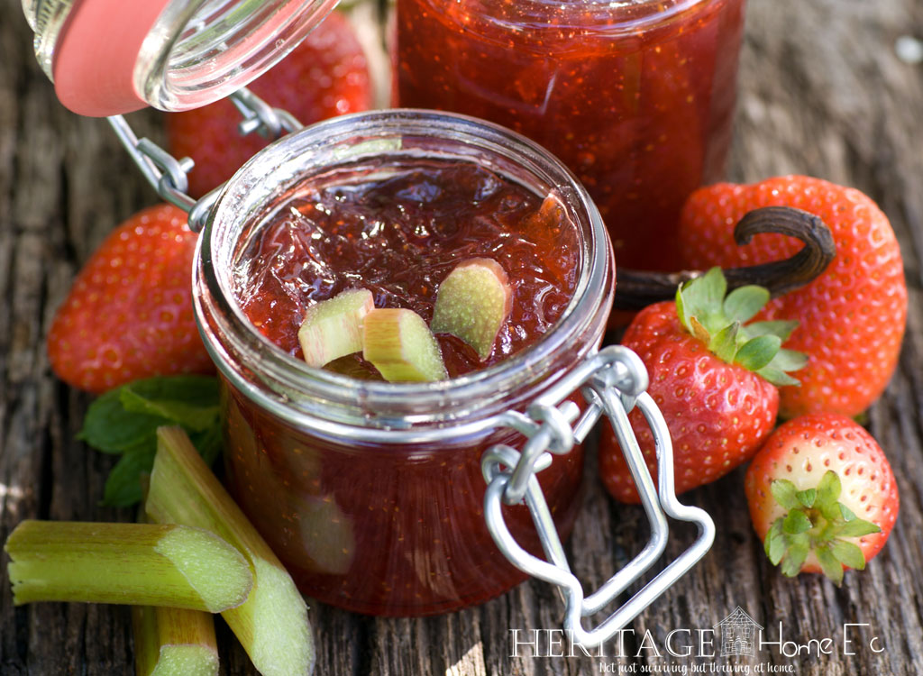 strawberry rhubarb jam with fresh rhubarb and strawberries on a wooden table