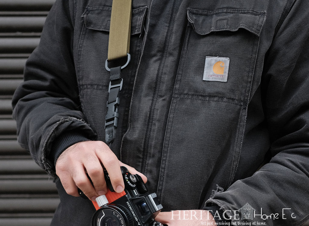 man wearing Carhartt coat with camera and strap