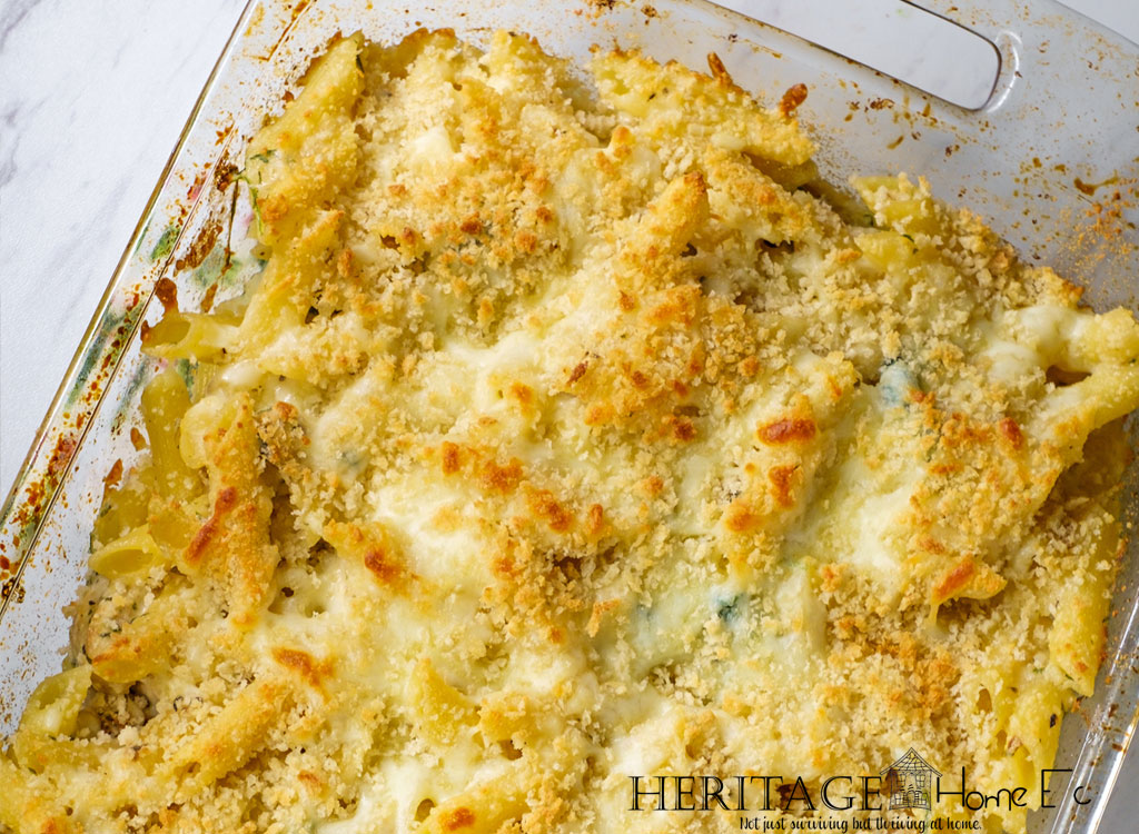 close up of zucchini and kale pasta bake in casserole dish with browned cheese