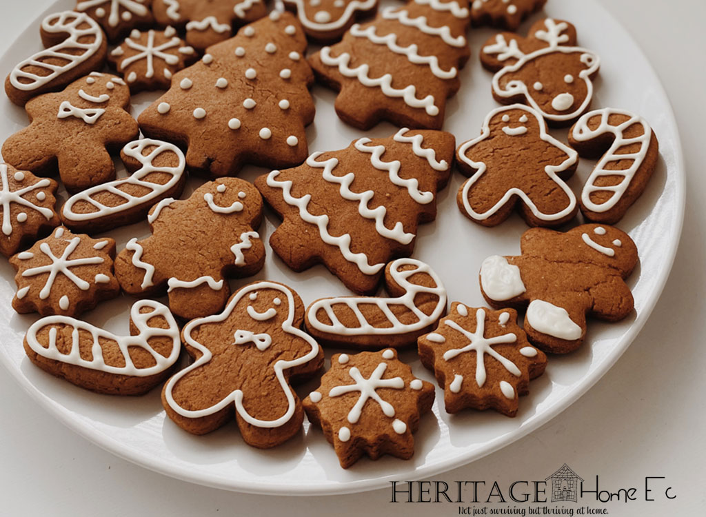 white plate of gingerbread cookies shaped as snowflakes, trees, candy canes and gingerbread men