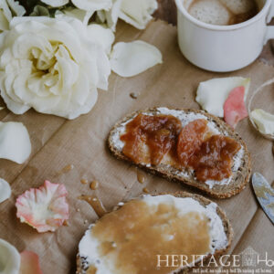 fruit spreads on whole-grain bread with cocoa and roses on a cardboard backdrop