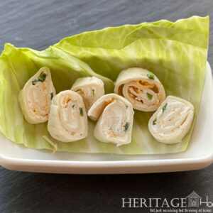 perfect party pinwheels in ceramic dish with garnish of cabbage leaf