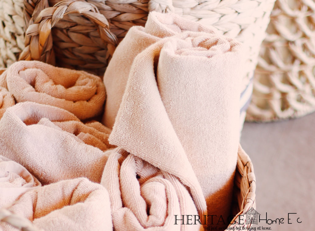 wicker basket of peachy pink towels rolled up