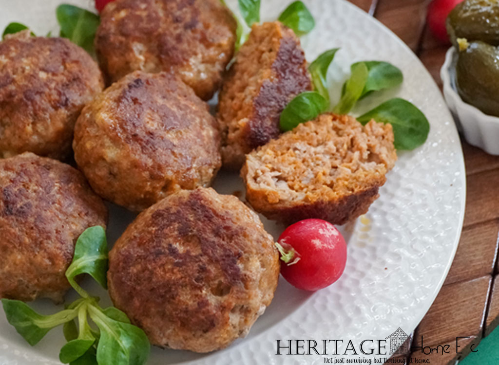 Meatballs with fresh herbs on a textured white plate