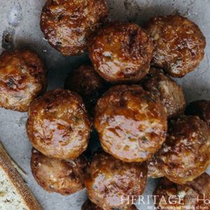 close-up on meatballs on a stone background flanked by crusty bread