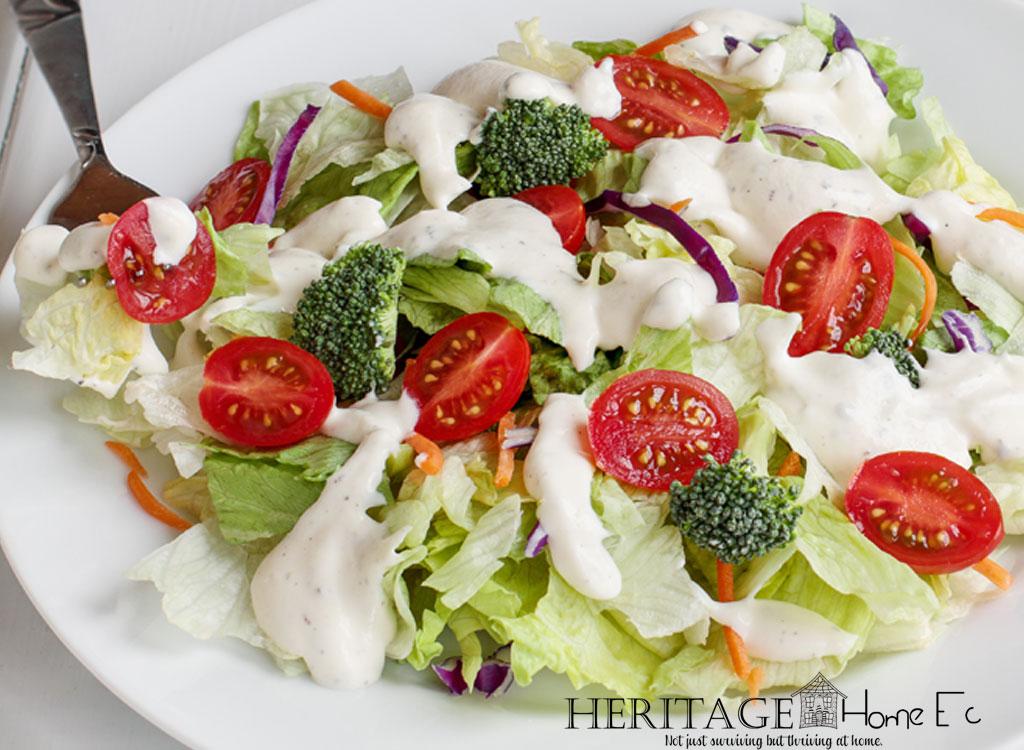 Homemade Ranch Dressing on a side salad of iceberg lettuce with shredded carrots, halved baby tomatoes and broccoli